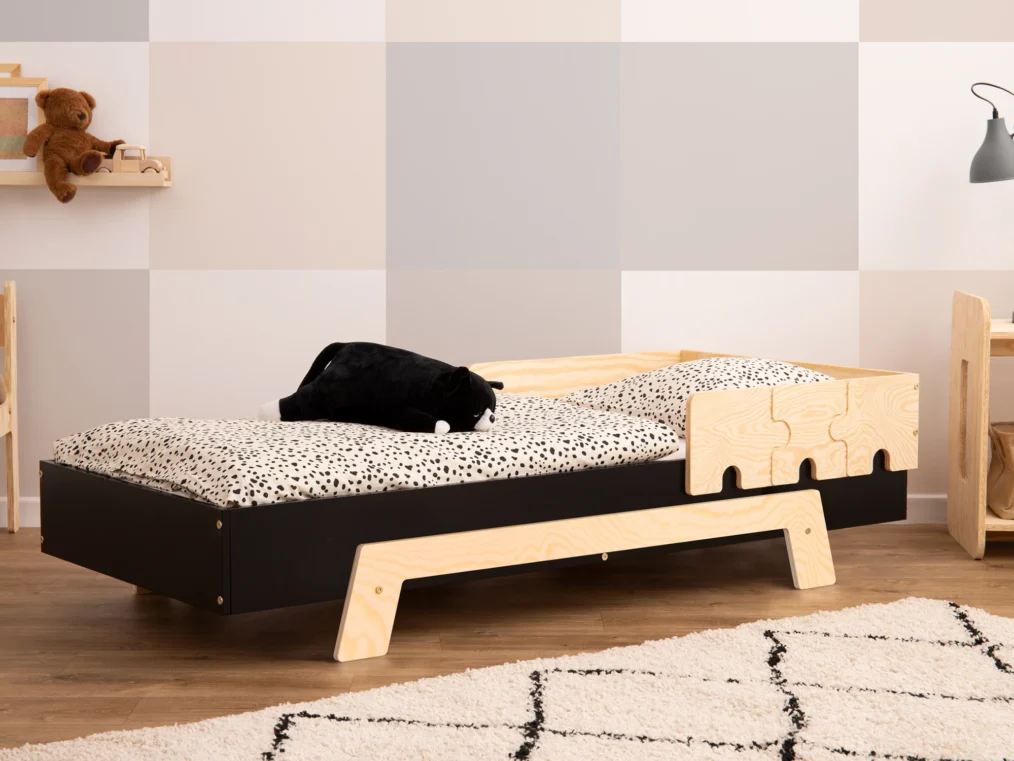 Lit en bois fabriqué en contreplaqué de pin avec une barrière en forme de puzzle en noir