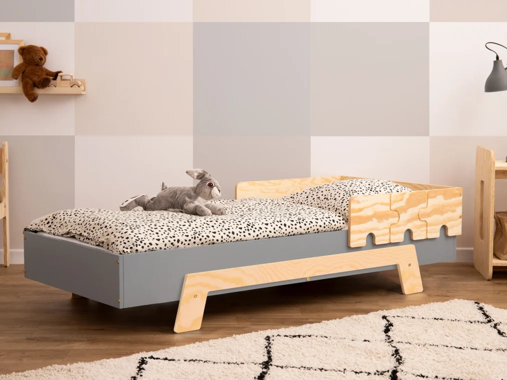 Lit en bois fabriqué en contreplaqué de pin avec une barrière en forme de puzzle en gris