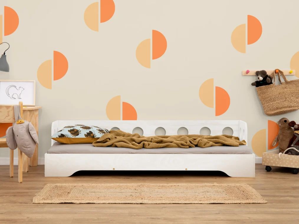 Lit en bois fabriqué en contreplaqué de pin couleur blanc avec une barrière à ouvertures rondes