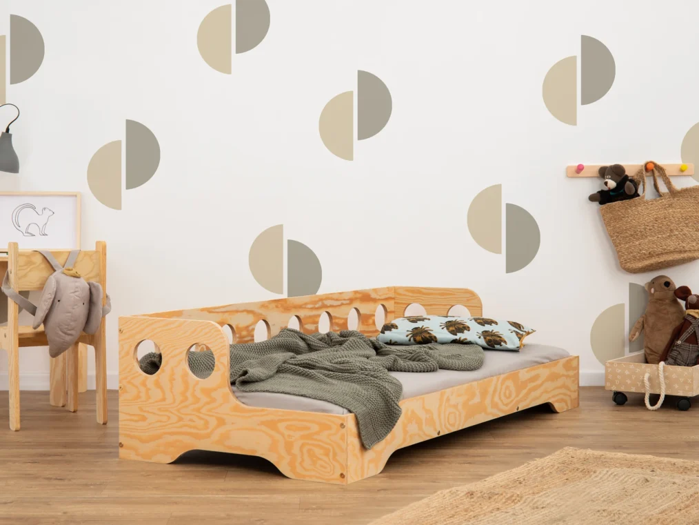 Lit en bois fabriqué en contreplaqué de pin couleur bois verni avec une barrière à ouvertures rondes