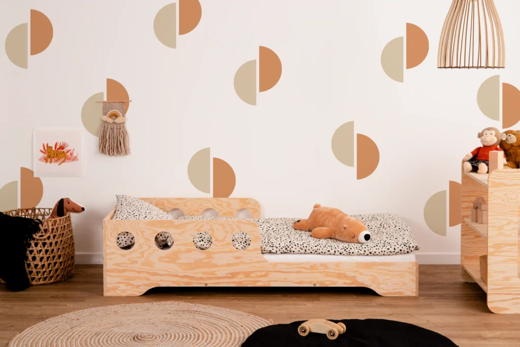 Lit en bois fabriqué en contreplaqué de pin couleur bois naturel avec une barrière à ouvertures rondes