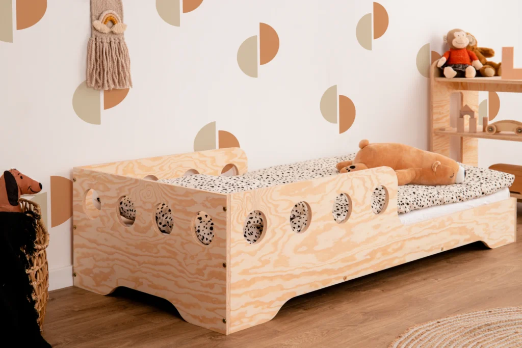 Lit en bois fabriqué en contreplaqué de pin couleur bois naturel avec une barrière à ouvertures rondes