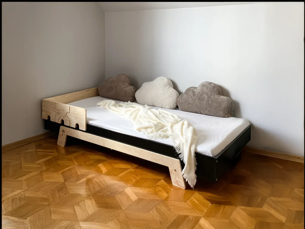 Lit en bois fabriqué en contreplaqué de pin de couleur noire avec une barrière en forme de puzzle