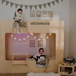 Lit superposé en bois naturel avec structure protectrice — deux enfants en train de jouer