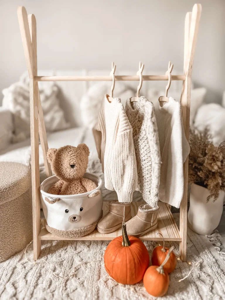 Porte-manteau en bois en forme de tipi avec des vêtements pour enfants suspendus