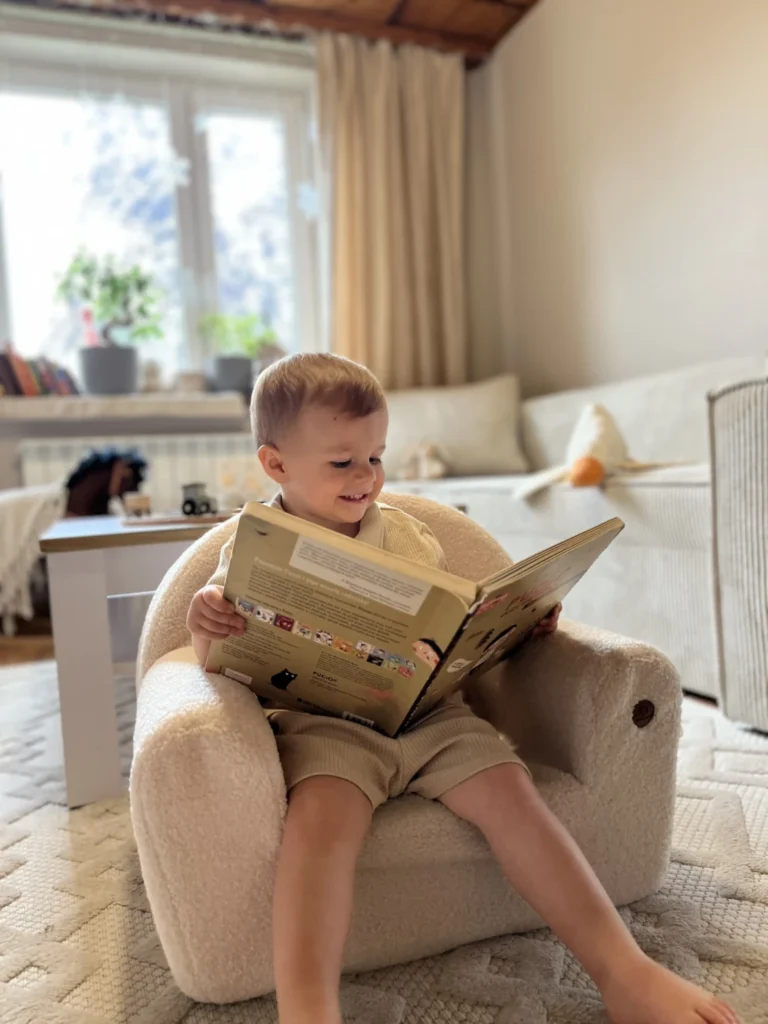 Enfant lisant un livre et assis sur un siège BUBU dans une chambre